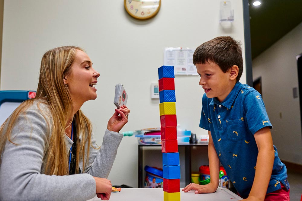 A women helping a boy with speech therapy