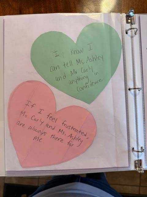 Heart shaped artwork with messages from children written inside
